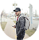 Man with glasses and backpack holding phone
